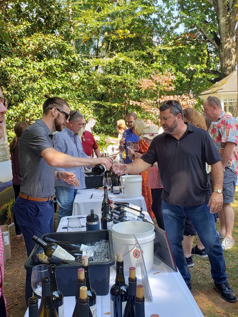 Vendor pouring wine into a glass held by a customer